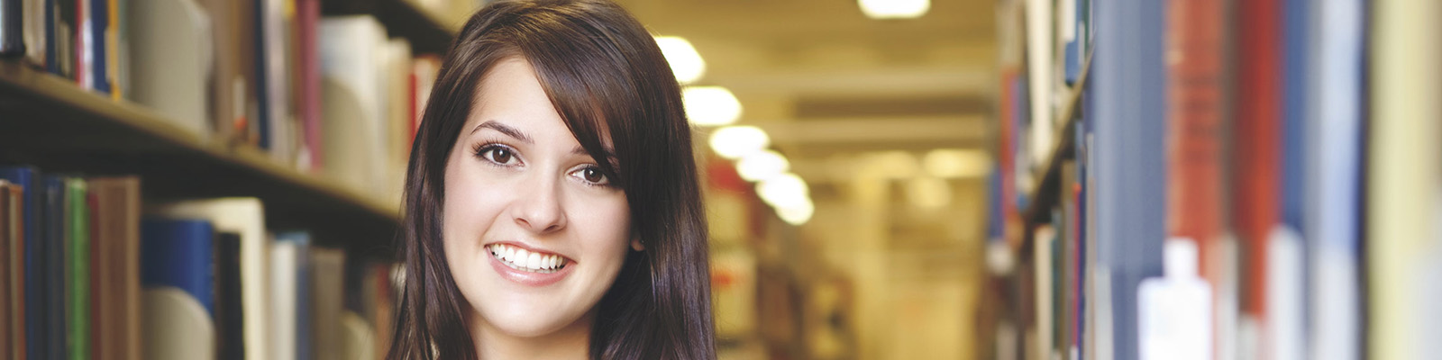 young woman in front of shelves of library books